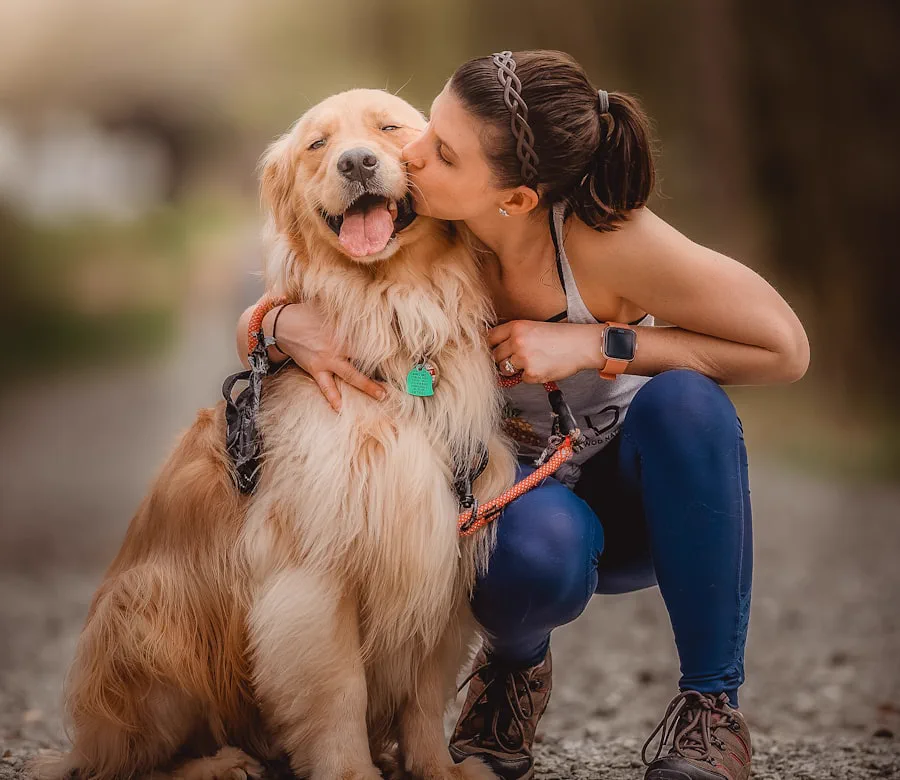 Proprietaria che bacia il suo golden retriever